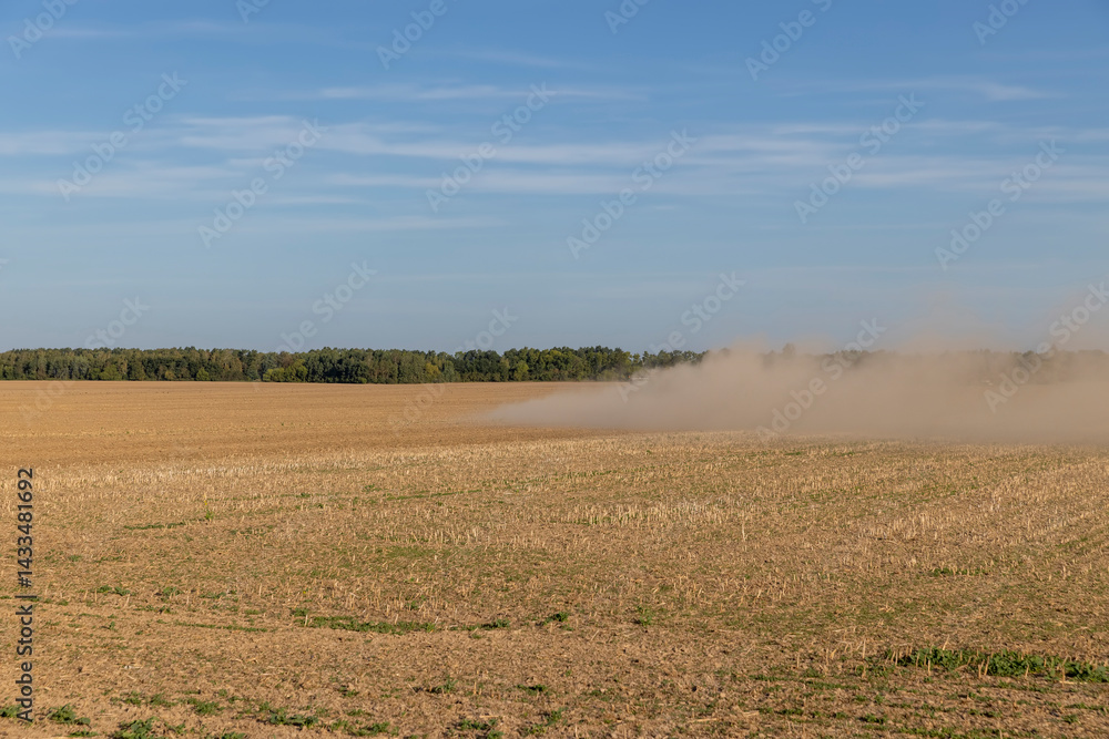 field after harvest during arable land, dry sand and dust in windy weather fly over the ground