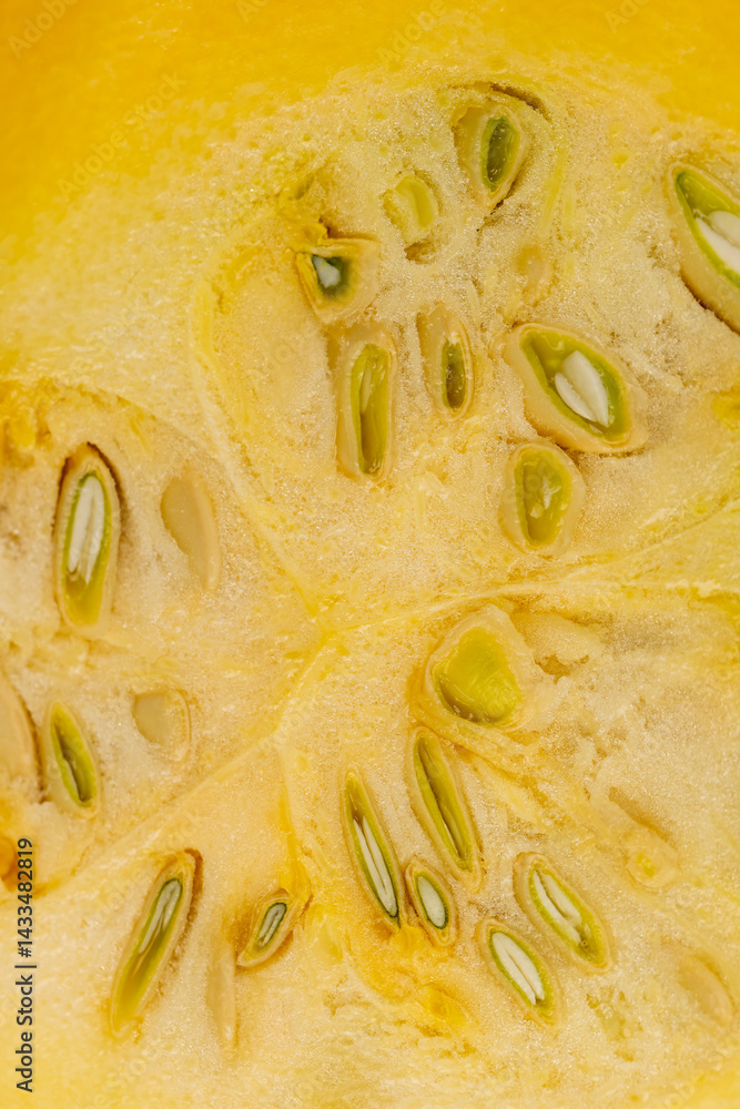 Slice yellow-orange ripe pumpkin or zucchini, slicing ripe zucchini on a black cooking table