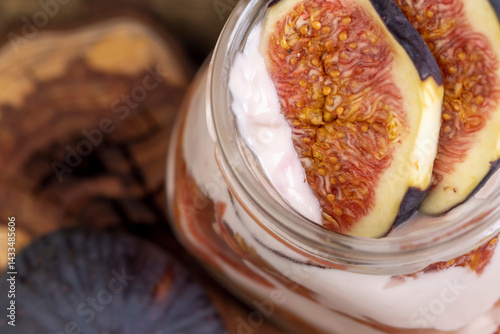 Obraz na płótnie fresh pink yogurt with fig flavor in a glass jar and with red figs cut into pieces, closeup w salonie