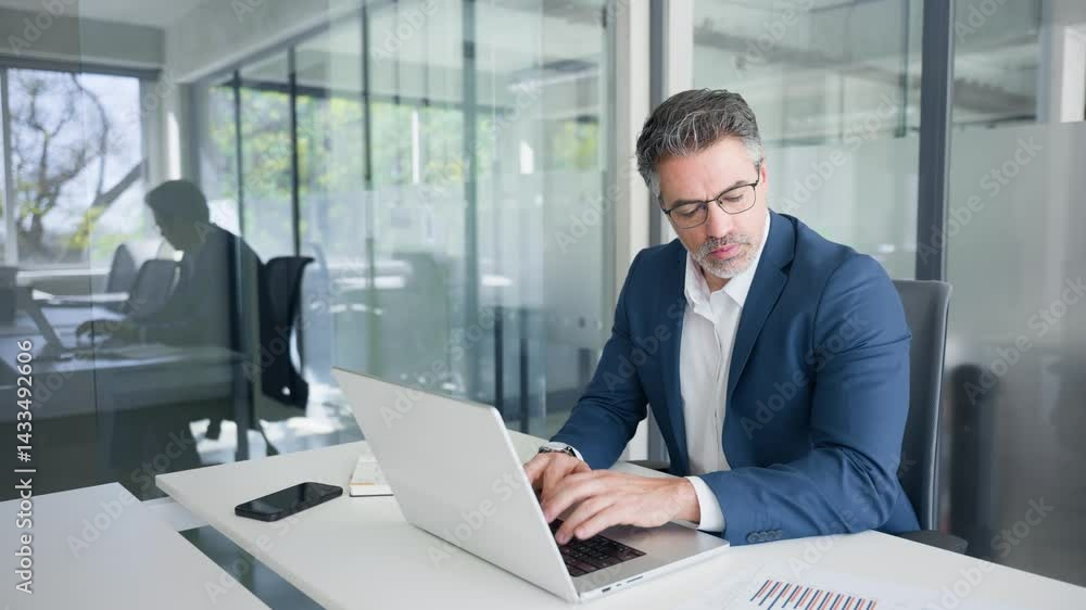 Concentrated financial specialist senior man working with finance sales document report on pc laptop computer in office. Mature executive businessman professional doing analysing of business sales