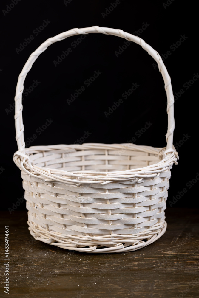 a white basket for food or other items, natural branches painted white from which a decorative basket is woven