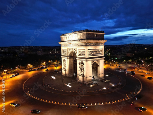 Paris  FRANCE - July 11, 2024: Paris Arc de Triomphe Triumphal Arch at Chaps Elysees at night, Paris, France. Drone view, Eiffel Tower in the background.  Architecture and landmarks of Paris. Postcard