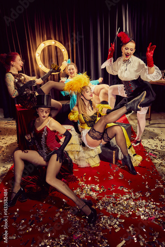 Elegant cabaret women in vintage posing with drinks, cigarettes and laughter on red carpet surrounded by confetti. Concept of cabaret, show, circus, retro, vintage, performance.