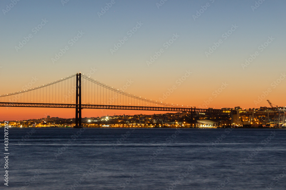 Naklejka premium 25th of April Suspension Bridge and Tagus River at Evening Twilight. Lisbon, Portugal. Blue Hour