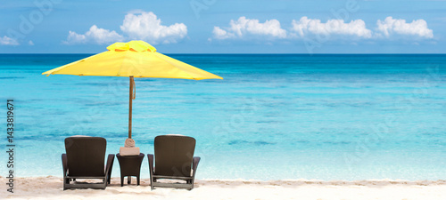 Fototapeta Naklejka Na Ścianę i Meble -   Beach scene with two beach chairs and yellow sun umbrella. Summer vacation on tropical sea. Travel destination
