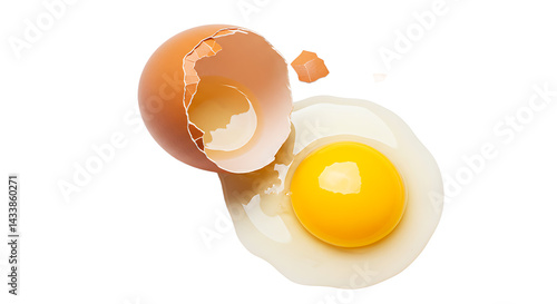 A cracked brown egg with the yolk and shell isolated on a black background in a studio shot