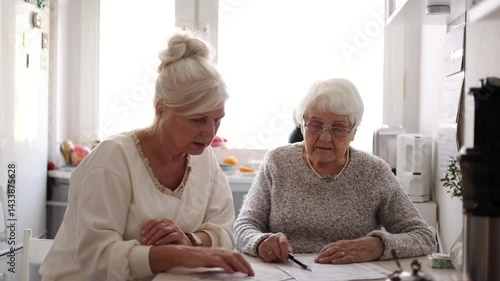 Woman helping her elderly mother preparing financial documents
