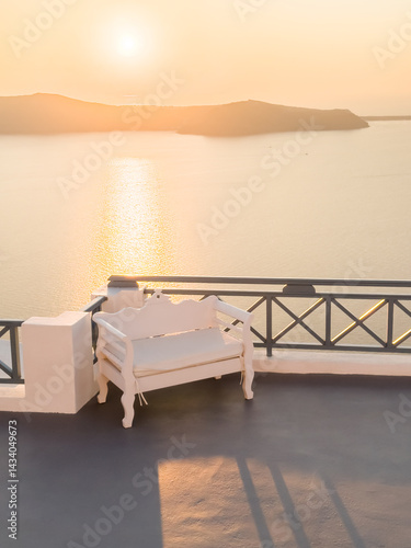 Obraz na płótnie Beautiful sunset at Santorini island, Greece. Chair on the terrace with sea view. w salonie