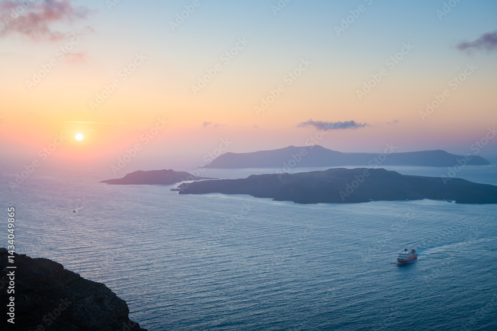 Pink foggy sunset at Santorini island, Greece. View of the sea and islands.