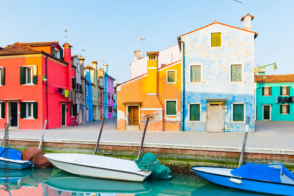 Colorful architecture in Burano island, Venice, Italy. Boats on the canal.