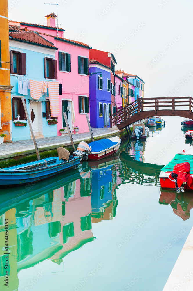 Colorful architecture in Burano island, Venice, Italy. Boats on the canal.