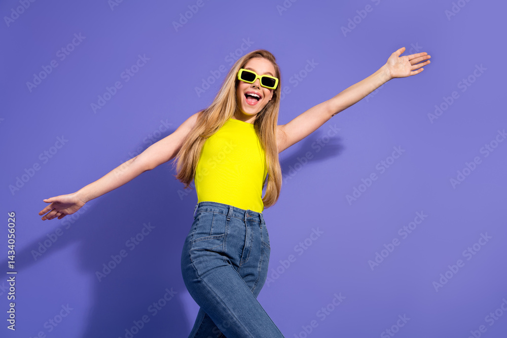 Joyful young woman wearing vibrant yellow top on a colorful background celebrating in relaxed style and trendy casual fashion