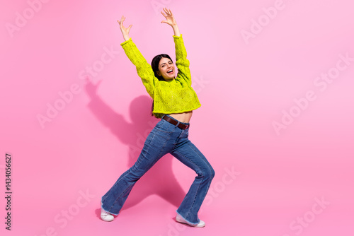 Obraz na płótnie Cheerful young woman showcasing trendy style with vibrant attire and joyful expression in a colorful studio setting w salonie