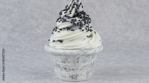 Swirled soft serve ice cream cone with black sprinkles