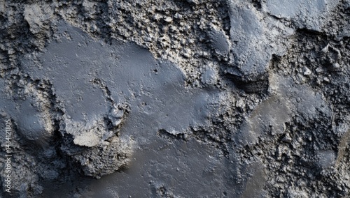 Close-up of a textured, dark gray surface with uneven patches and a rough, grainy appearance