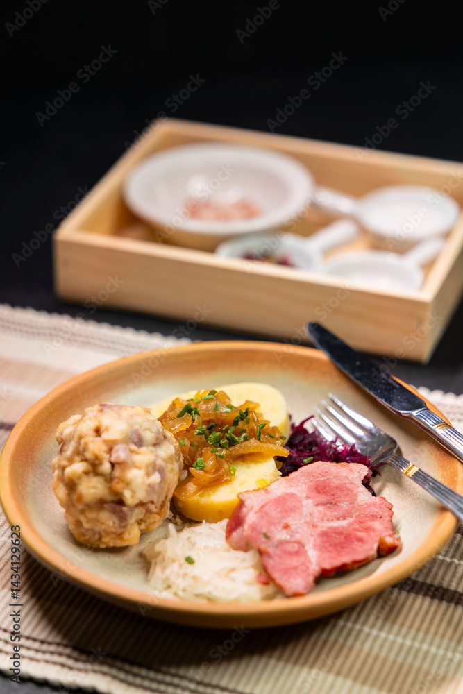 Bavarian dumplings with roasted pork, sauerkraut and potato dumpling lying on a plate