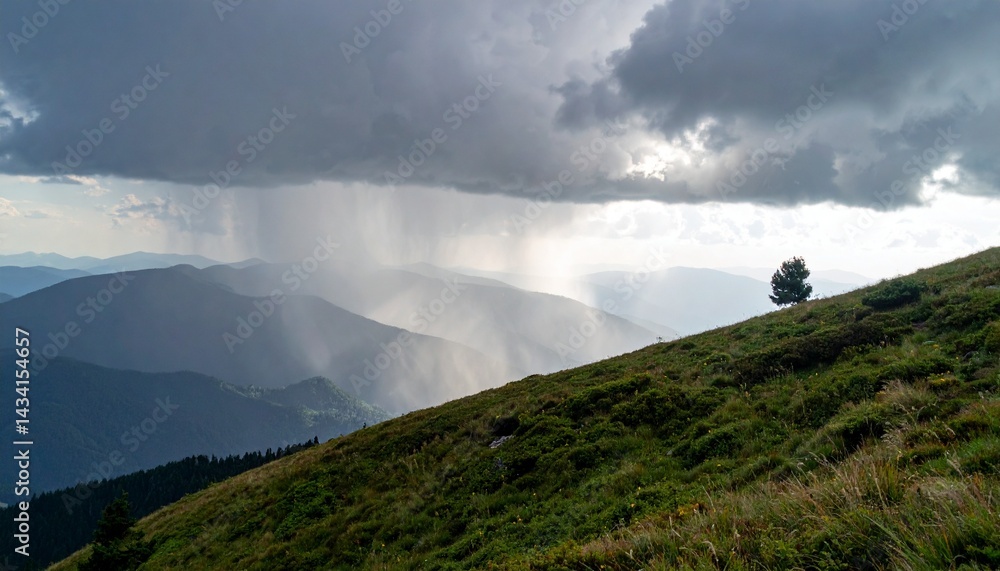 Rain falling over a mountain ridge under thick storm clouds as sunlight breaks through in the distance Rain falling over a mountain ridge under thick storm clouds as sunlight breaks through in the distance