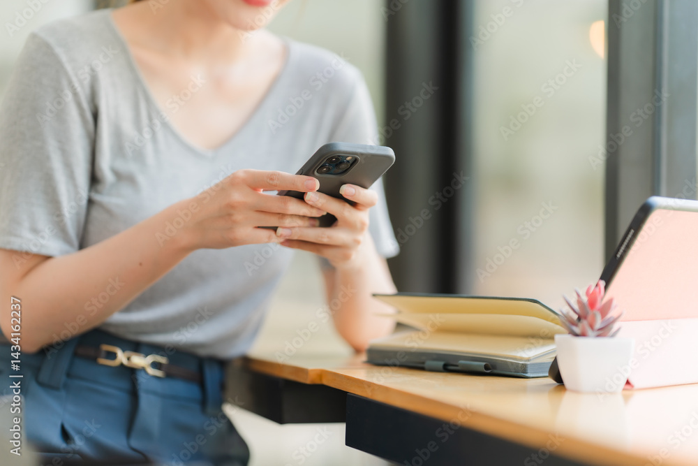Woman Using Smartphone at Desk Woman Using Smartphone at Desk
