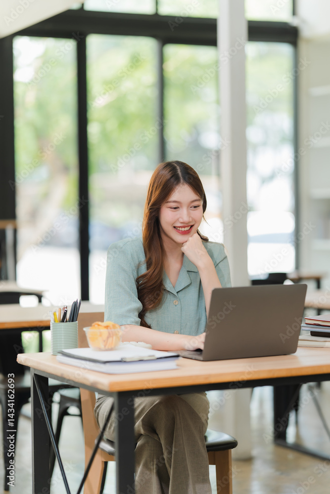 Smiling Woman Working on Laptop at Desk Smiling Woman Working on Laptop at Desk
