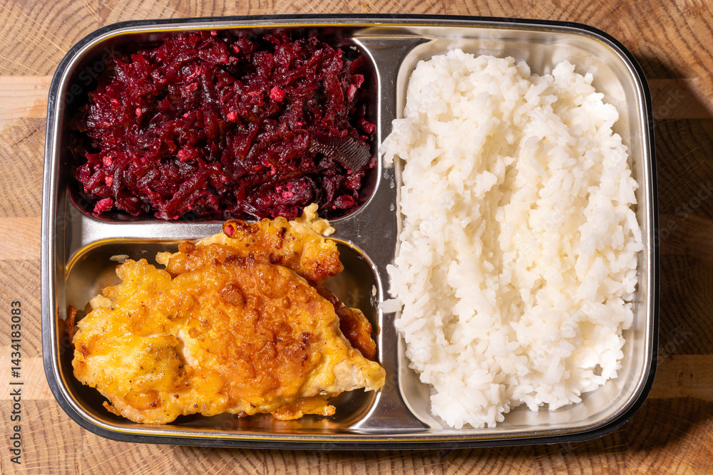 A metal food tray with three compartments: red beets in one, a fried cutlet in another, and white rice in the third.