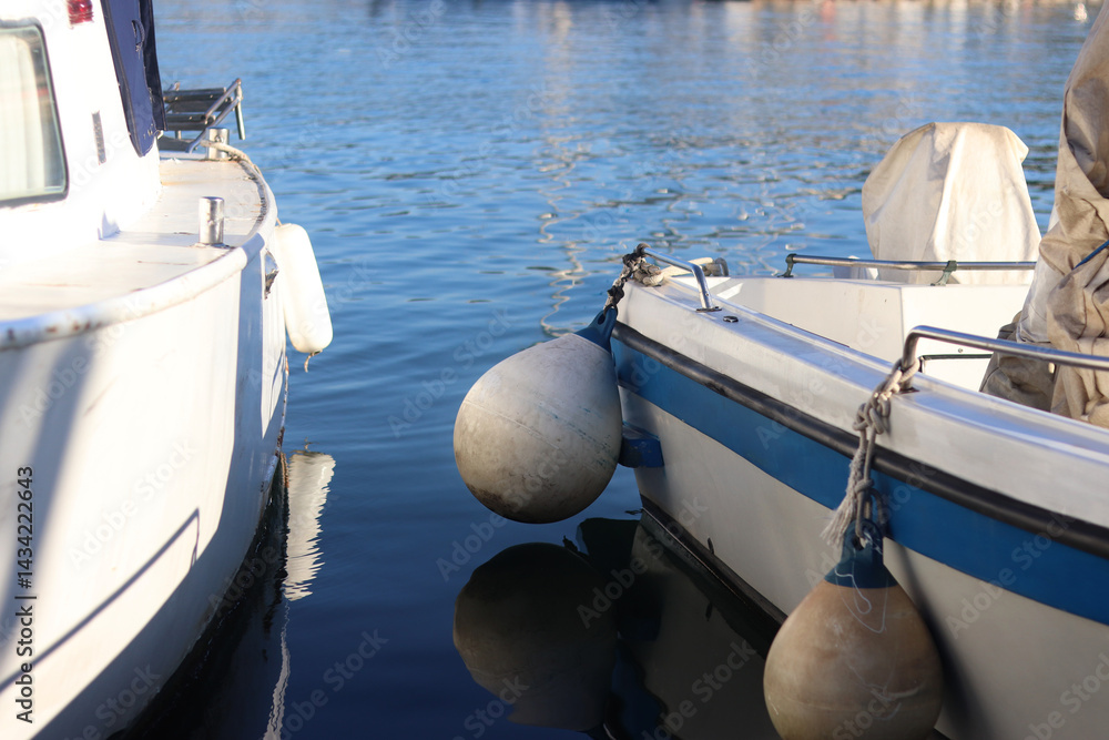 Boats moored to the pier. Details. Small boats on the water, close-up. Summer sunny day on the pier. Old boats. Vacation at sea