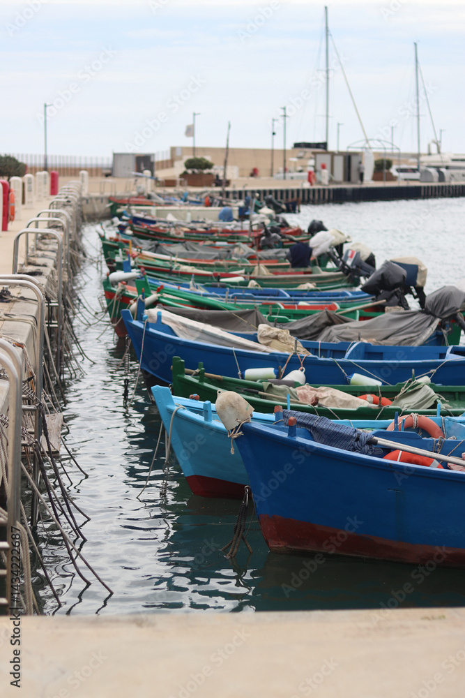 Boats moored to the pier. Details. Small boats on the water, close-up. Summer sunny day on the pier. Old boats. Vacation at sea