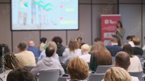 Wallpaper Mural People attending a seminar in a conference room, actively listening to a speaker on stage. Torontodigital.ca
