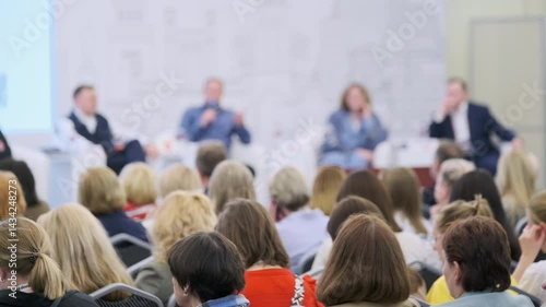 Audience gathered at a professional conference watching and listening to an expert panel discussion.