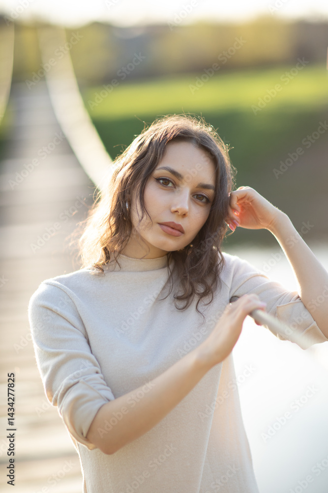 Portrait of a beautiful young brunette woman in the park. Asian girl in a white sweater