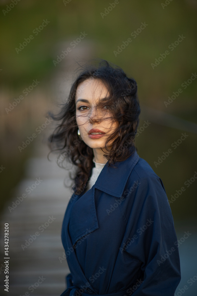 Portrait of a beautiful Asian woman with long black hair and wearing blue coat.