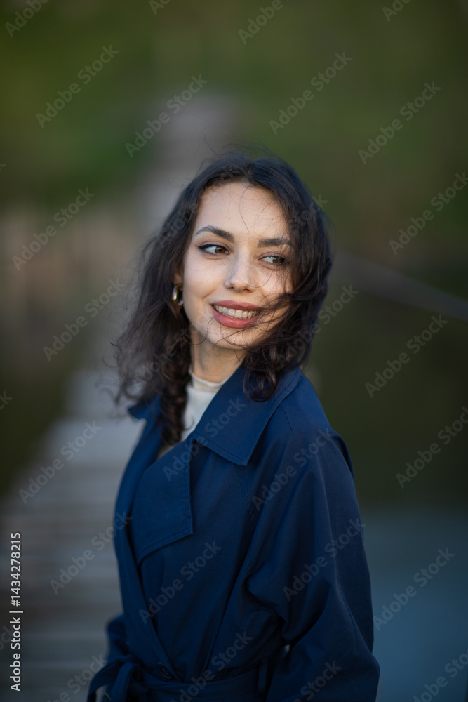 Portrait of a beautiful Asian woman with long black hair and wearing blue coat.
