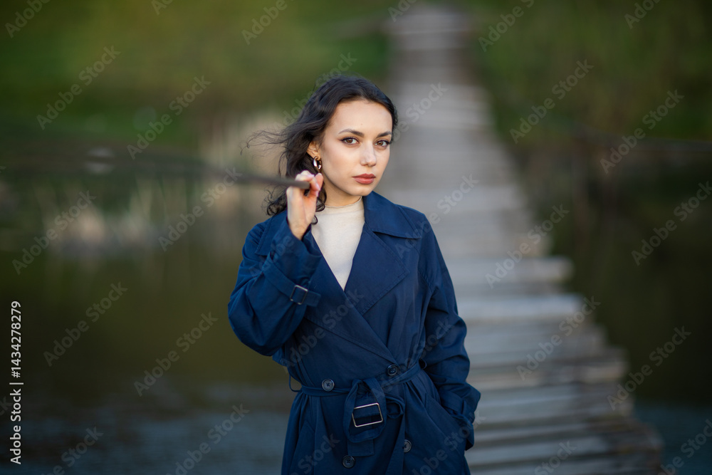 Portrait of a beautiful Asian woman with long black hair and wearing blue coat.