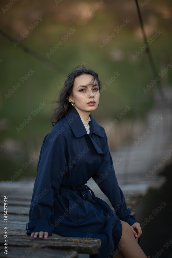 Portrait of a beautiful Asian woman with long black hair and wearing blue coat.