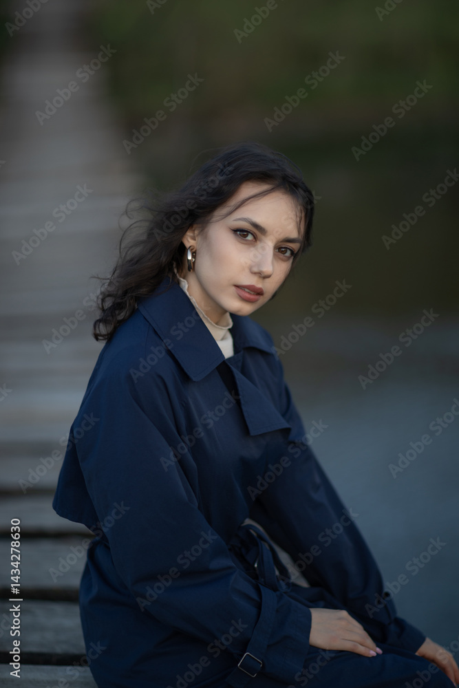 Portrait of a beautiful Asian woman with long black hair and wearing blue coat.