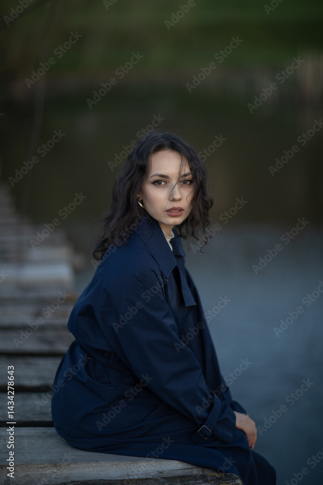 Beautiful brunette meditates sadly in the park in the evening light. Sad girl