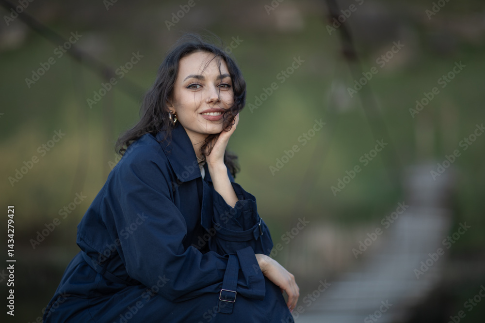Portrait of a beautiful Asian woman with long black hair and wearing blue coat.