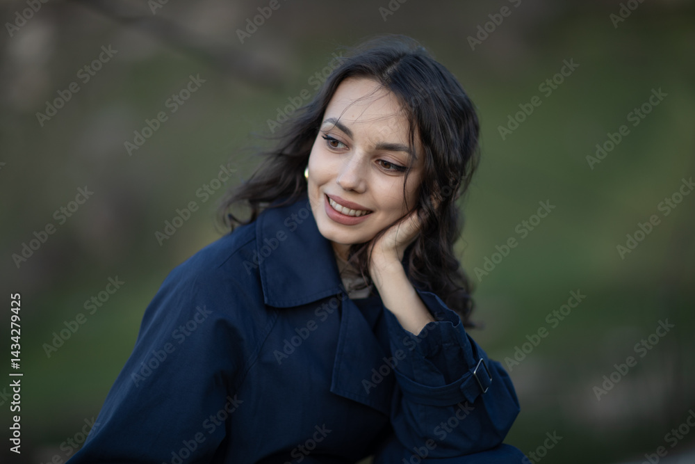 Portrait of a beautiful Asian woman with long black hair and wearing blue coat.