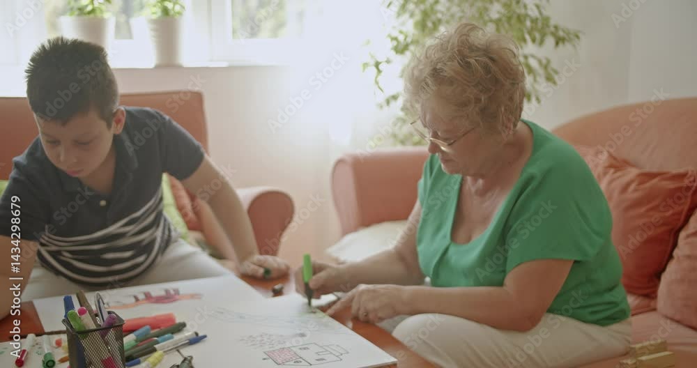 A grandmother and her grandson enjoy a relaxing afternoon drawing together, creating a warm and loving family moment. A grandmother and her grandson enjoy a relaxing afternoon drawing together, creating a warm and loving family moment.