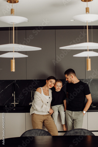 Happy family posing in modern kitchen with designer lamps
