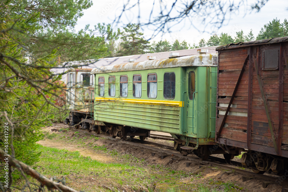 Green train car is parked on the tracks. The train car is old and rusty Green train car is parked on the tracks. The train car is old and rusty