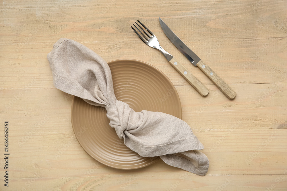 Plate with cutlery and napkin on wooden background Plate with cutlery and napkin on wooden background