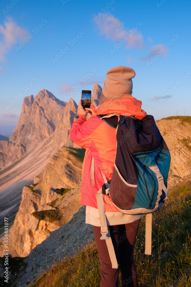Girl standing on top of mountain taking pictures of landscape. Girl with backpack for mountain hiking. Mountain landscapes in summer. Place for mountain weather, travel and vacation.