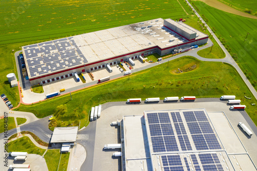 Industry with low carbon footprint. Industrial warehouses with solar panels on the roof. Technology park and factories from above