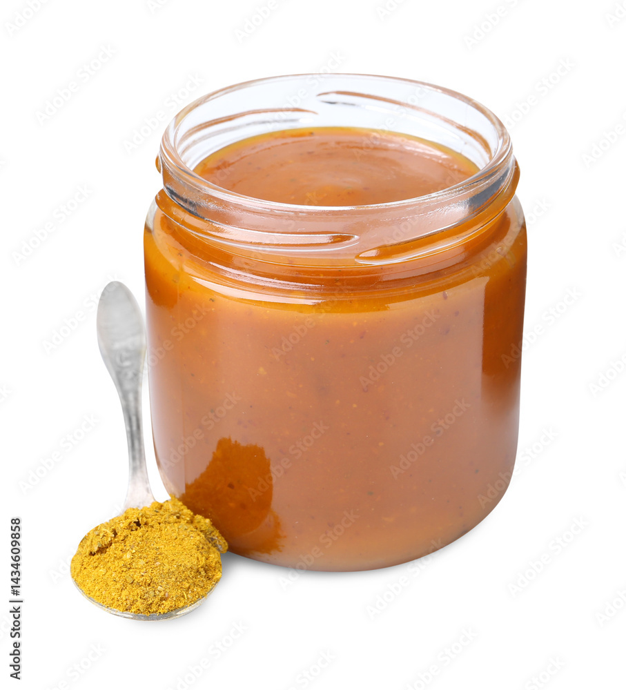 Tasty curry sauce in glass jar and spoon with powder isolated on white Tasty curry sauce in glass jar and spoon with powder isolated on white