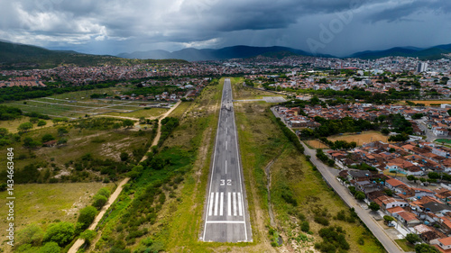 Short of the landing strip 32 in small airport, aerial view with mountains