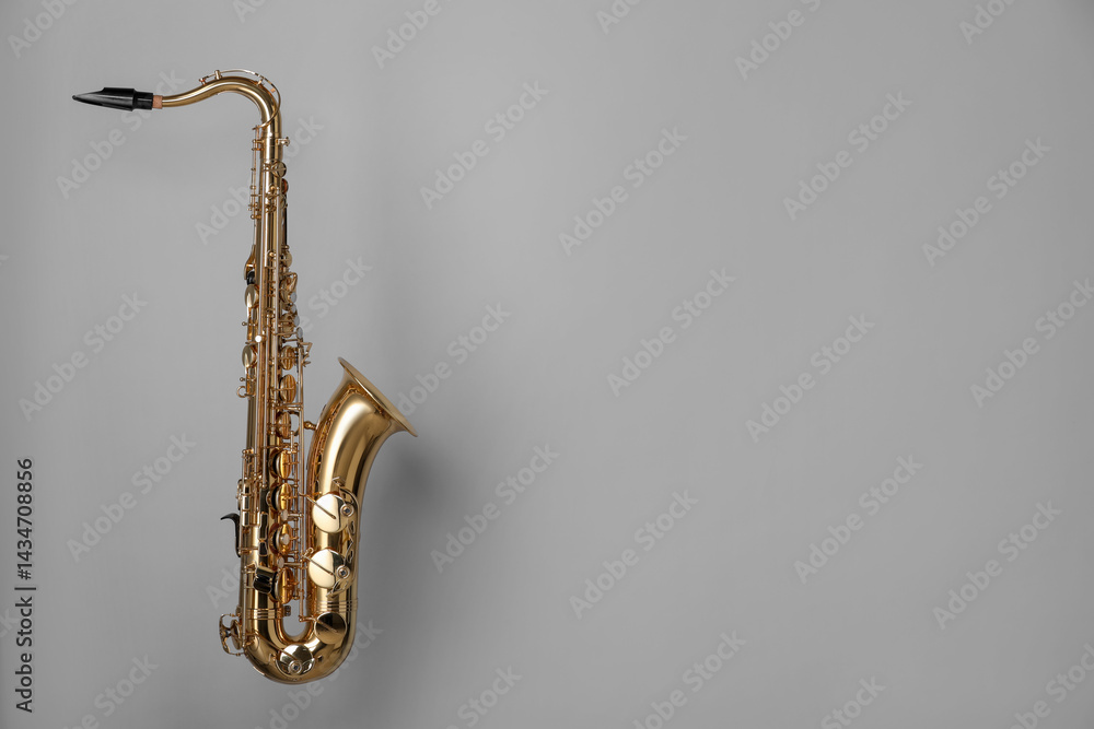 Fototapeta premium Golden saxophone on grey background. Space for text