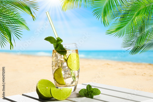 Fototapeta Naklejka Na Ścianę i Meble -  Refreshing cocktail on wooden deck under green palm leaves on sunny tropical beach