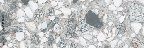 Concrete wall texture with pebbles. Decorative rough concrete surface with white, black and gray stones. Perfect for background and design. Closeup. High resolution.