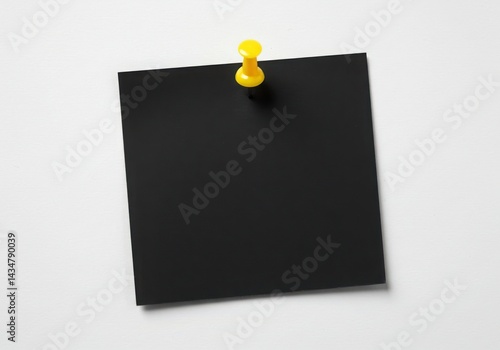 Black note with yellow pin isolated on white background