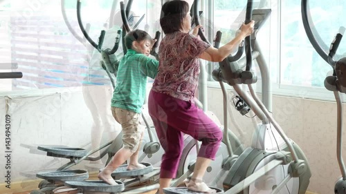 Video shows fun elliptical exercise rhythm between aunt and nephew in the gym, family activity.
